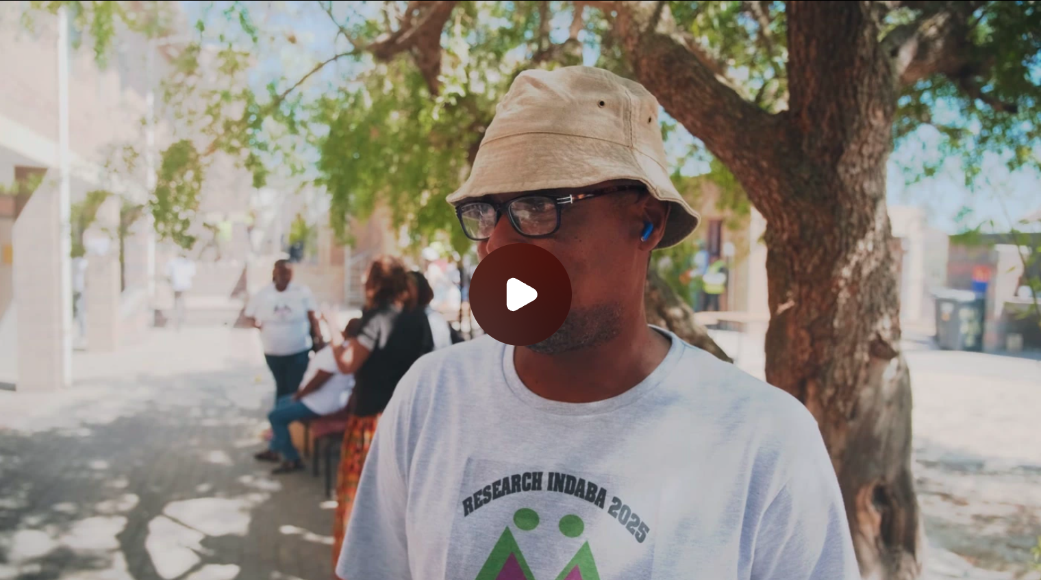 Man with bucket hat and t-shirt that reads Research Indaba 2025